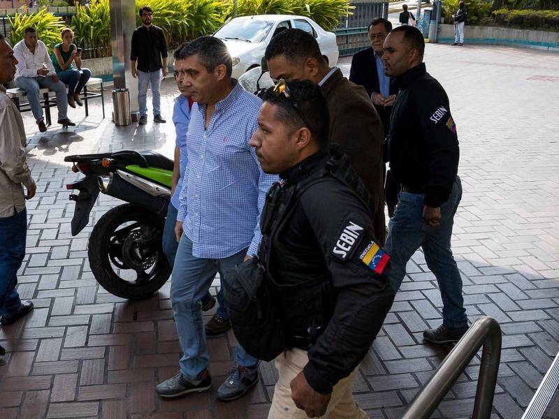 Venezuelan security forces have detained former minister Miguel Rodriguez (C) on conspiracy charges.
