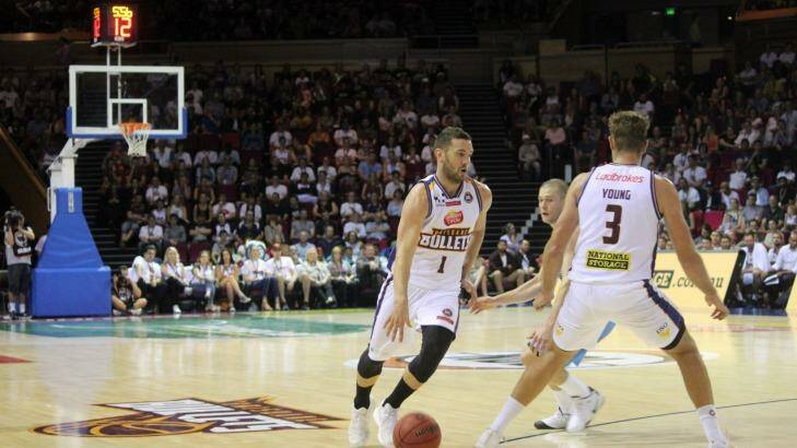 Brisbane Bullets point guard dribbles round a screen set by teammate Mitch Young. Photo: Joshua Paterson