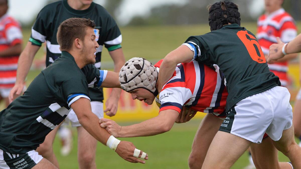 March 24. The Riverina Anglican College v Kildare Catholic College. Kildare's Derek Hay is held up close to the line by the TRAC's Ed Ansell and Daniel Downes. Picture: Michael Frogley 