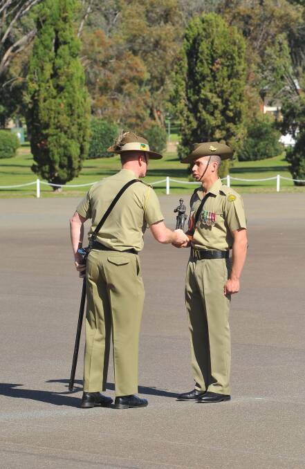 Anzac Day march out at Kapooka. Reviewing Officer, Lieutenant Colonel Glen Ryan CSC, presents the trophy to Private David Palu for most outstanding soldier in 36 platoon. Picture: Kieren L Tilly 