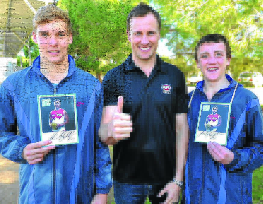 HAPPY DAYS: Sydney Swans champion Jude Bolton signs autographs for Kildare Catholic College students Adam Whyte, 12, and Nick Anderson, 14, at the Giants Cup at Maher Oval yesterday. Picture: Kieren L Tilly