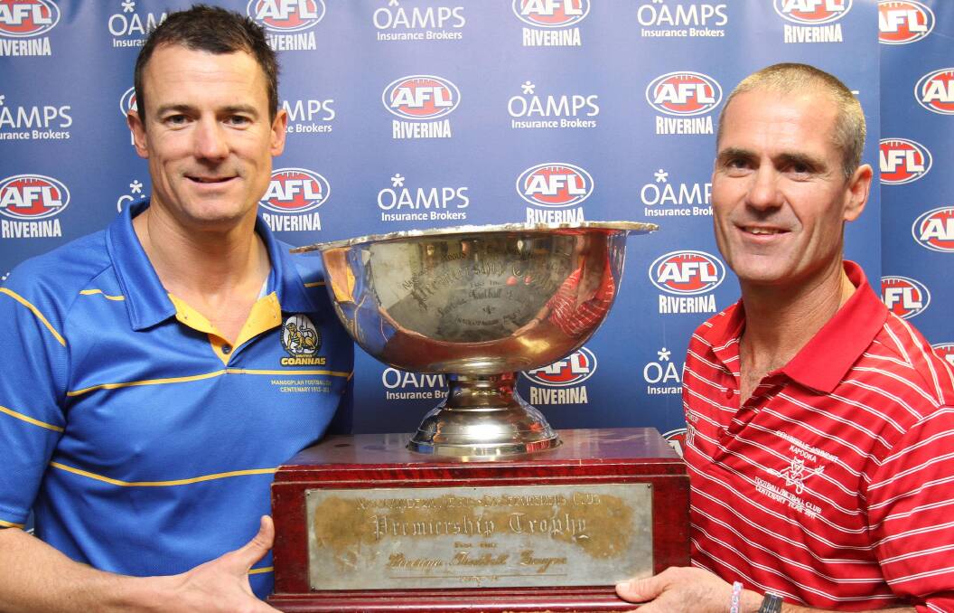 BRING IT ON: Mangoplah-Cookardinia United-Eastlakes coach Nathon Irvin (left) and Collingullie-Ashmont-Kapooka coach Shane Lenon get their hands on the Riverina Football League trophy at AFL House on Wednesday ahead of Sunday's grand final. Picture: Kieren L Tilly