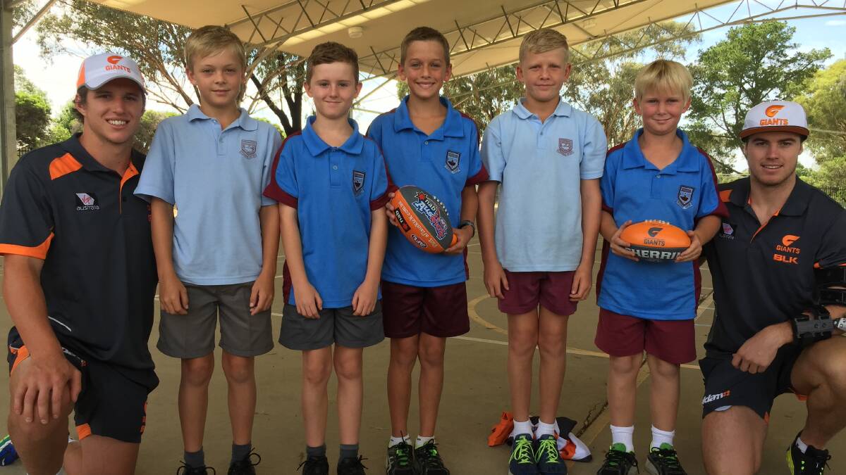 BIG FANS: Greater Western Sydney (GWS) footballers Jake Barrett (left) and Lachie Plowman (right) spend time getting to know Kooringal Public School's (from left) Jake Hockley, 11, Thomas Casnave, 10, Luke Lawrence, 10, Jake Scott, 10, and Euan King, 9, on Monday. Picture: Matt Malone