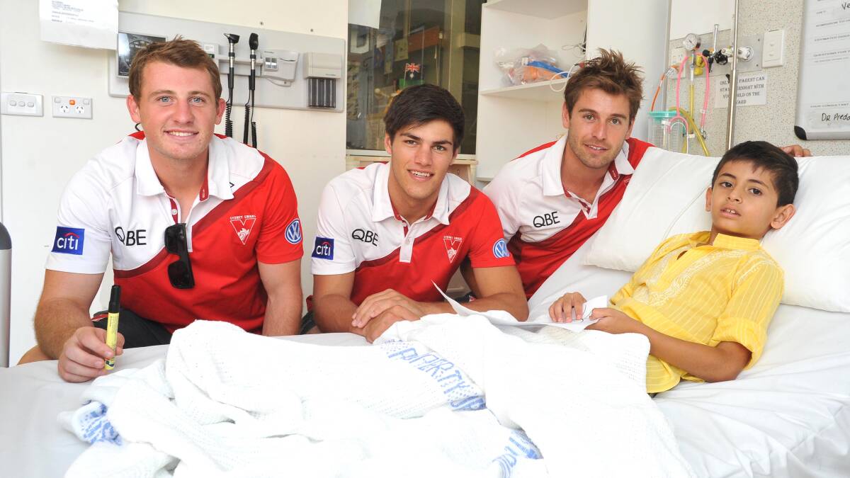 SPECIAL VISIT: Sydney Swans players Harry Cunningham, Lewis Melican and Nick Smith visit Arkaan Shah, 7, at the Wagga Base Hospital Children's Ward on Monday. Picture: Laura Hardwick