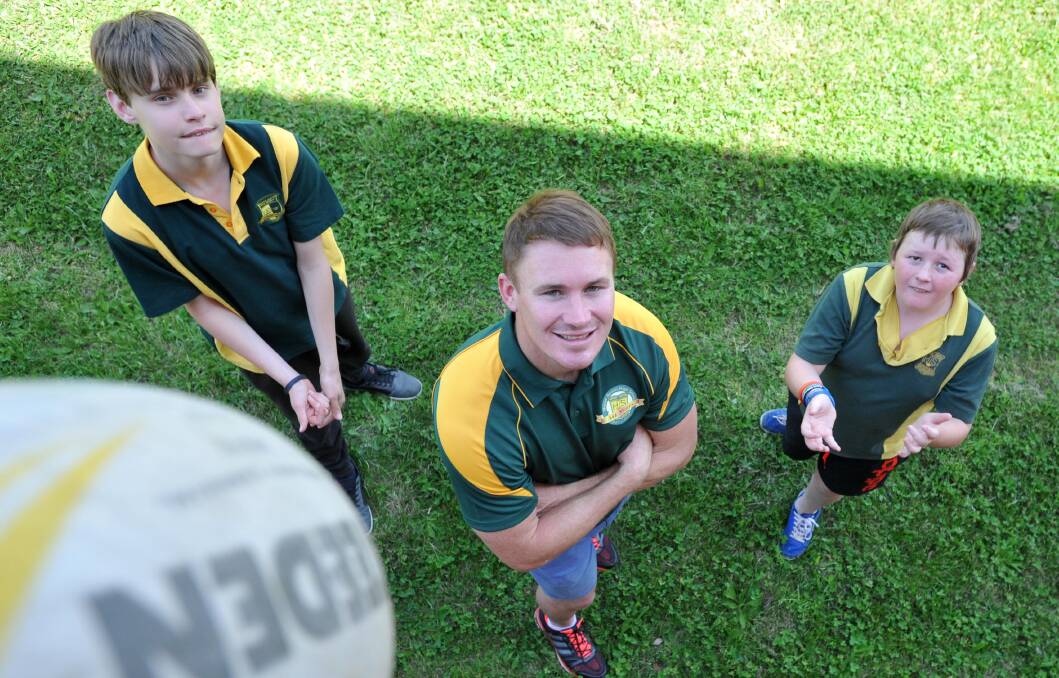 BALL PLAYERS: New Southcity captain-coach Nick Skinner has some football fun with Mt Austin High students Miles Burge, 14, and Sam Robinson, 13, at the Wagga school on Monday. Picture: Michael Frogley 
