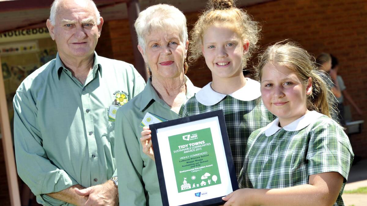 GREEN SCHOOL: Wagga Tidy Town Sustainable Community committee Graham Jackaman and deputy chairwoman Elsie Kimball presents Lutheran students Aine Guifoyle, 11, and Gabrielle Miller, 12, with an award recognising environmental education. Picture: Les Smith