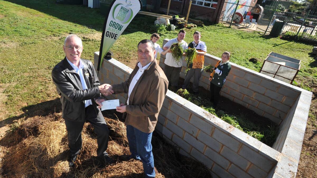 IN THE COMPOST: MAHS deputy principal Bruce Fisher receives a donation from Interface's Brendan Hogan as students Connor Griffin,16, Tom Melbourne, 17, Kai Batten, 16, and Katrina Hincksman, 17, watch on. Picture: Michael Frogley
