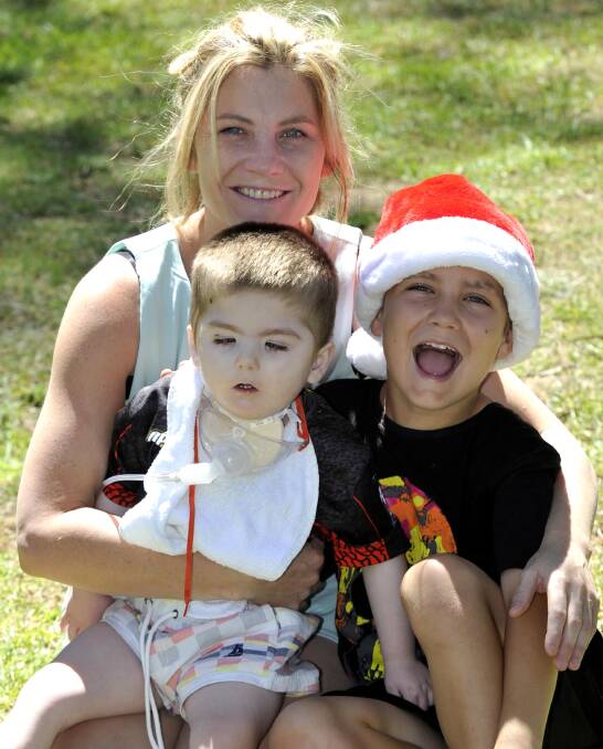 FAMILY FIRST: Alissa Heffey with sons Jacob Heffey, 3, and Ryan Hilder, 10, enjoy the Christmas party at Botanic Gardens. Picture: Les Smith