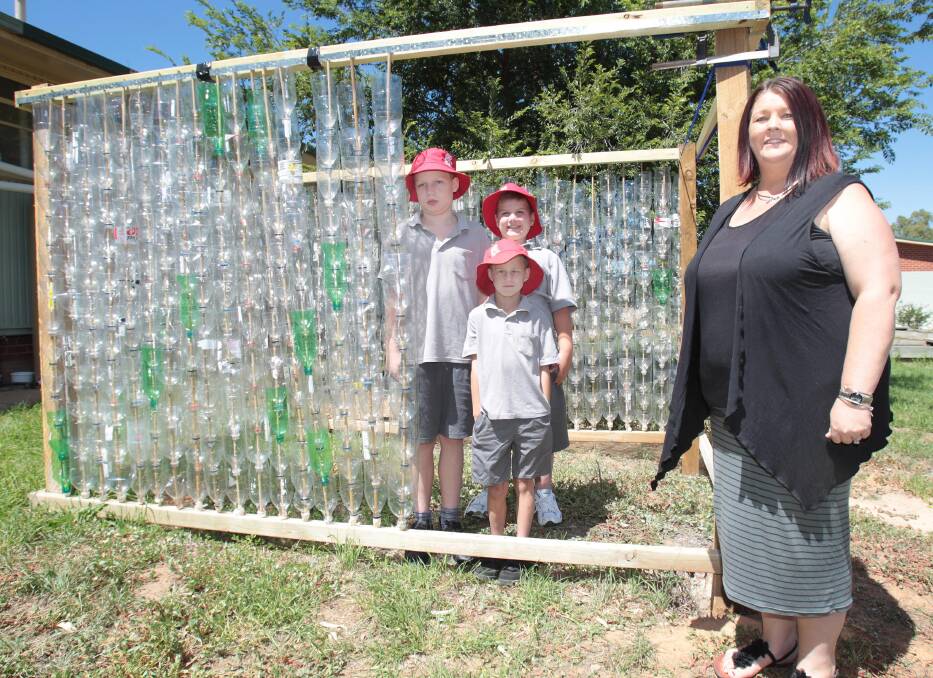 GREEN THUMBS: Mount Austin Public School students (front) Joshua Puckeridge, Alec Ramsay and (back) Jack Mottee look over the school's new greenhouse with teacher Toni Watts. The greenhouse is made from recycled plastic bottles and will help the students raise vegetable seedlings. Picture: Kieren L Tilly