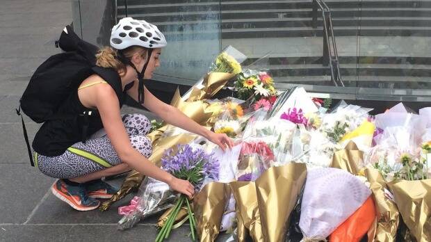 Glebe cyclist Eve Burchfield leaves flowers in Martin Place. Photo: Emma Partridge