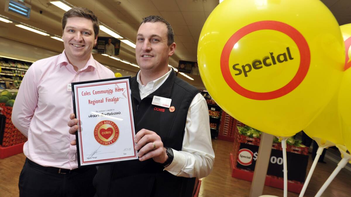 Coles Sturt Mall store manager Jason Bortolazzo (right) is congratulated on being named one of the company's Community Heroes by regional HR manager Aaron Trott. Picture: Les Smith