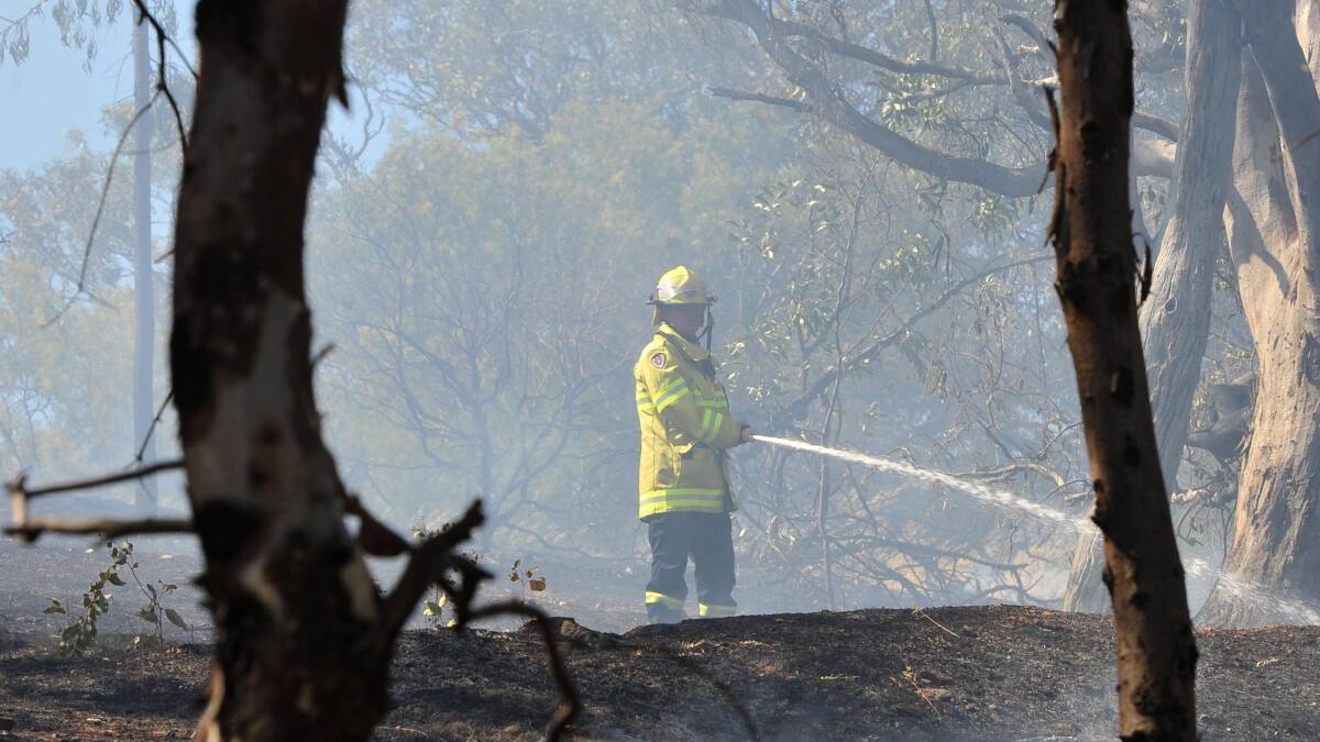 A firefighter mops up a small fire near Bourkelands on Wednesday. Picture: Laura Hardwick