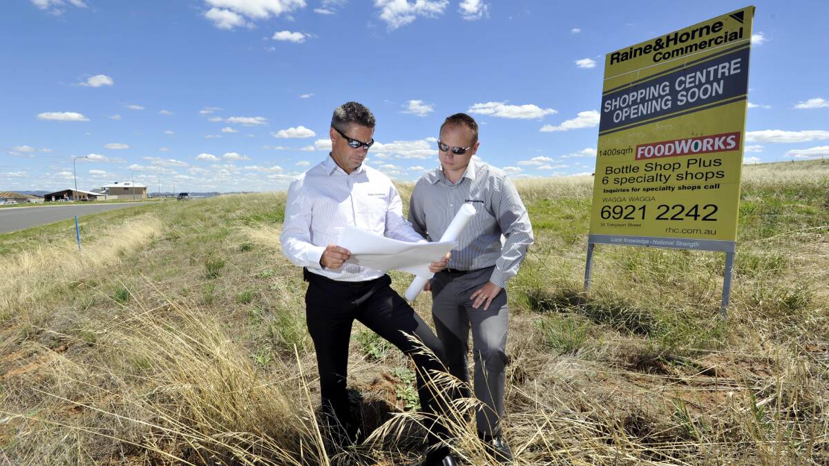 Raine and Horne commercial sales and leasing agent Dean Pinney and director Grant Harris look over plans for the proposed new Estella shopping centre. Picture: Les Smith