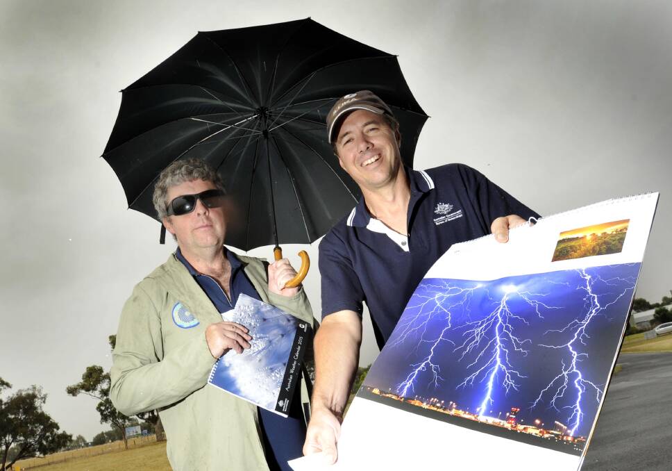 Bureau of Meteorology Wagga acting officer Robbie Lennard and technical officer Nigel Smedley show off the organisation's new 2015 weather calendars. Picture: Les Smith