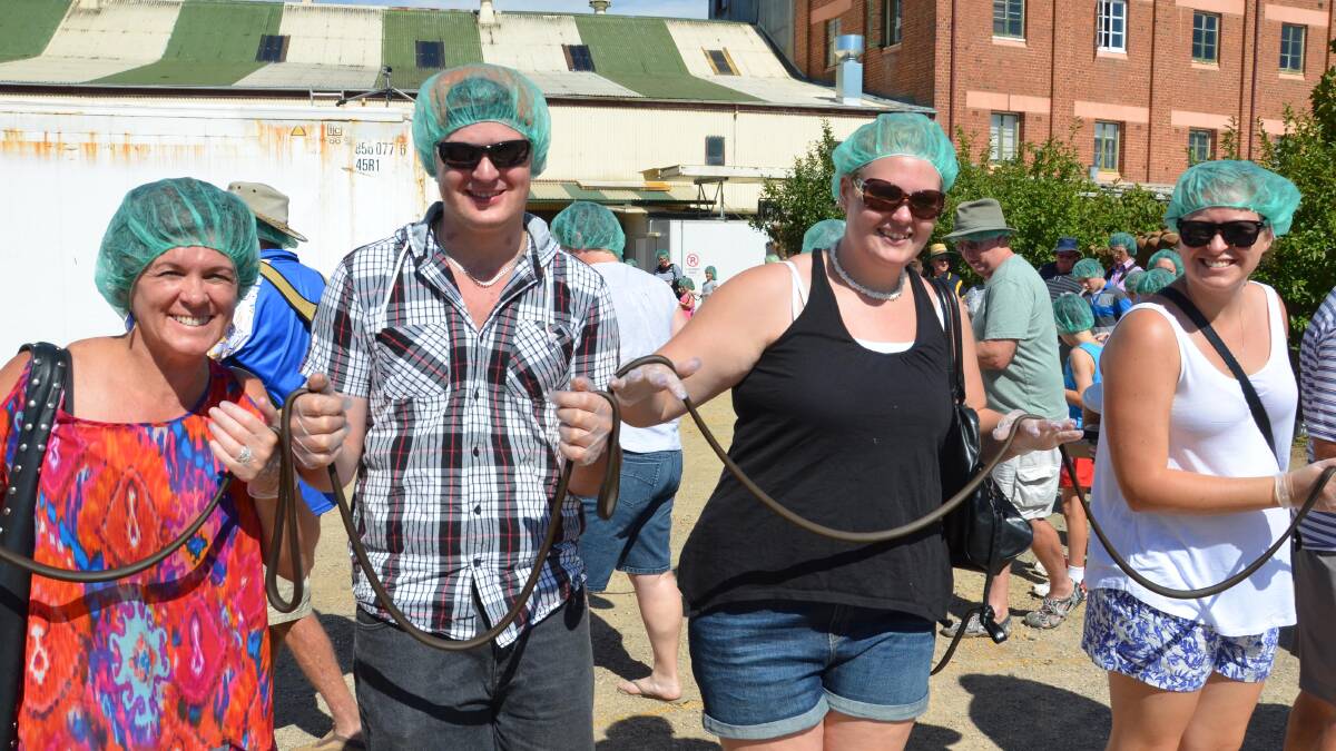 Narelle Wood from Wollongong, Damian Britt from Gundagai, Tash Seton from Junee and Laura Douglas from Wollongong take part in the world's longest licorice strap attempt. Picture: Declan Rurenga