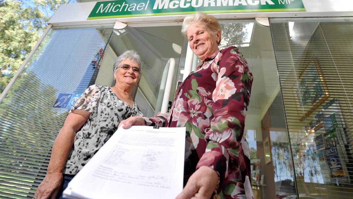 WE NEED COVERAGE: Wantabadgery resident Maggie Salisbury (right) and her friend Gail Ryan (left) march on Member for Riverina Michael McCormack's office to present a 500-strong petition to see the villages mobile black spot became a thing of the past. Picture: Alastair Brook