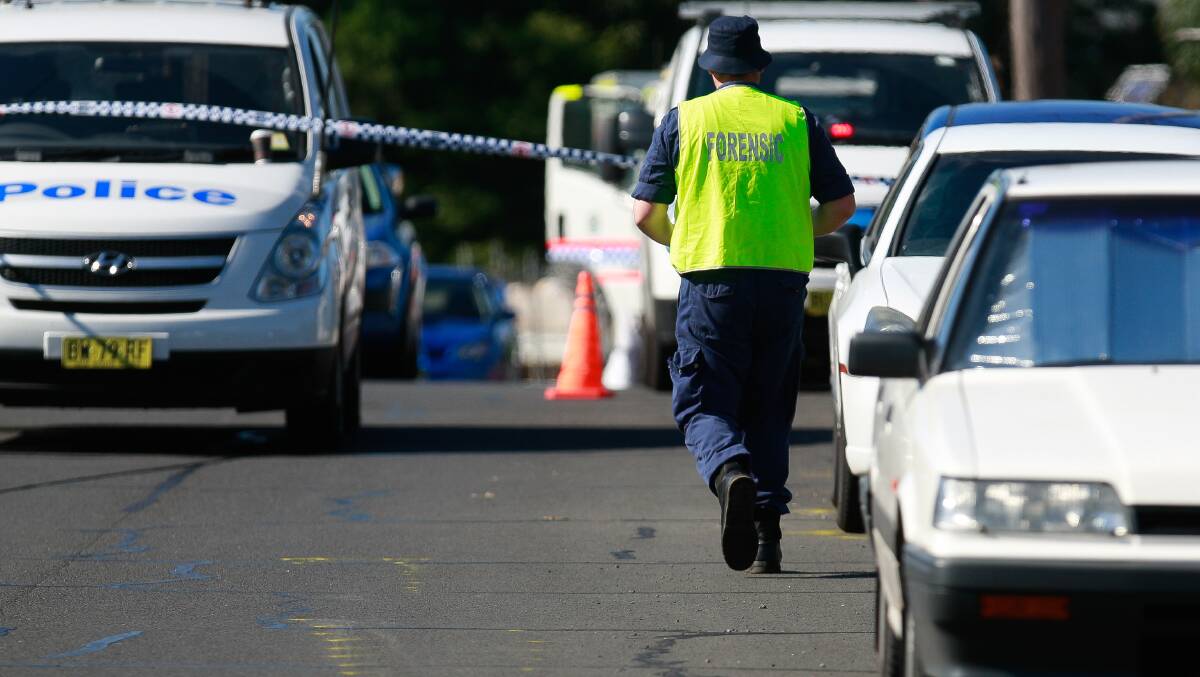 Police and police forensics investigate a suspected hit-and-run on Northcliffe Drive, Lake Heights. Picture: CHRISTOPHER CHAN