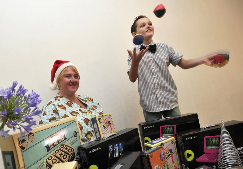 GREAT PERFORMANCE: James Illsley, 9, with Wagga Base Hospital children's ward nurse Kim Gordon and the gifts James bought for the ward with money he raised by juggling outside Jardines Cafe. Picture: Les Smith