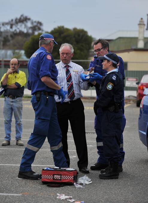 SLASHED: Paramedics treat Kerry Flinn for a cut hand after he was slashed by a drug-affected teenager in 2012.