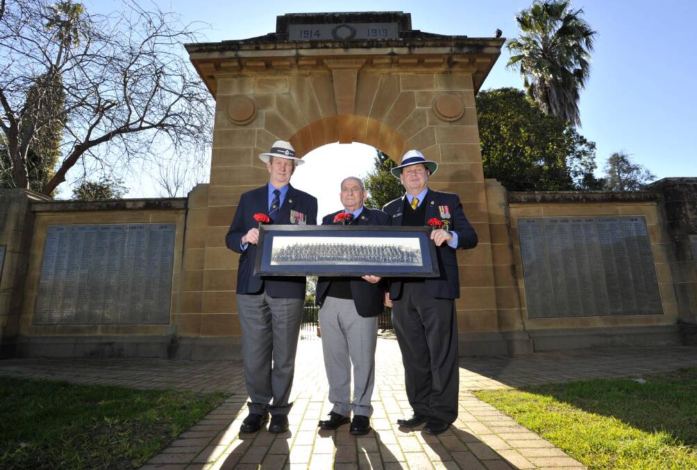 LEST WE FORGET: At the memorial arch in the Victory Memorial Gardens holding a picture of WWI recruits are (from left) RSL sub-branch president Kevin Kerr, vice-president Harry Edmonds and treasurer Brian Watts. Picture: Les Smith