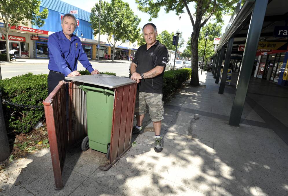 FIX IT UP: Greg Breust (left) and David Harmer with a garbage bin that needs fixing near their Baylis Street shops. Picture: Les Smith