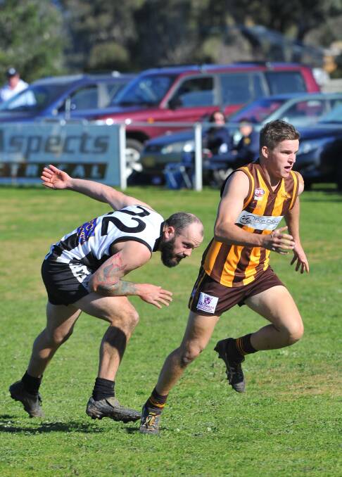 TRYC player Dennis Pedemont and EWK's Nick Baggio compete for the loose ball at Gumly Oval. Pictures: Kieren L Tilly