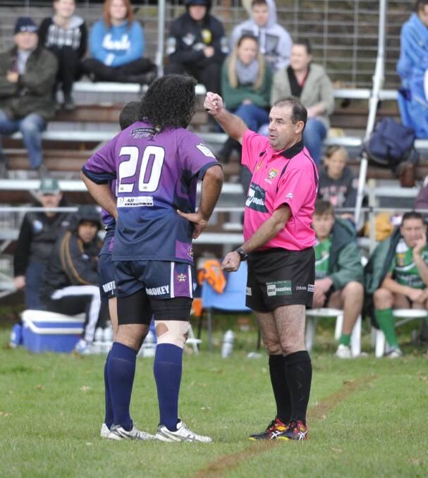 Referee Bernie Nix has a chat to Southcity forward Wayne Goolagong during the game.
