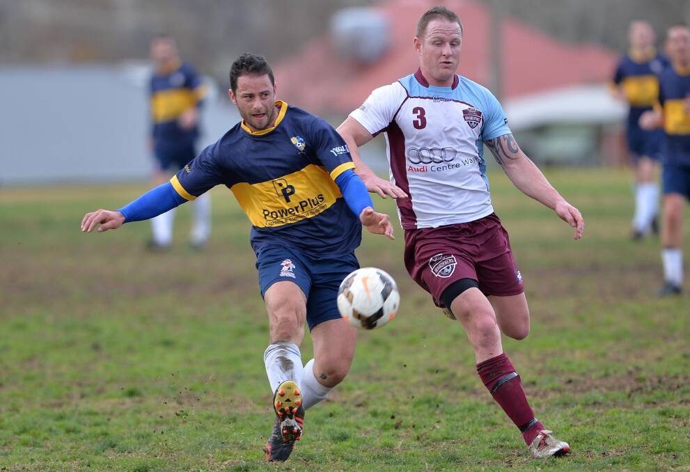 Wanderers defender Matt Barnes moves in for the challenge as Yoogali SC opponent Michael Depoali gets a kick away at Gissing Oval on Saturday. Pictures: Michael Frogley