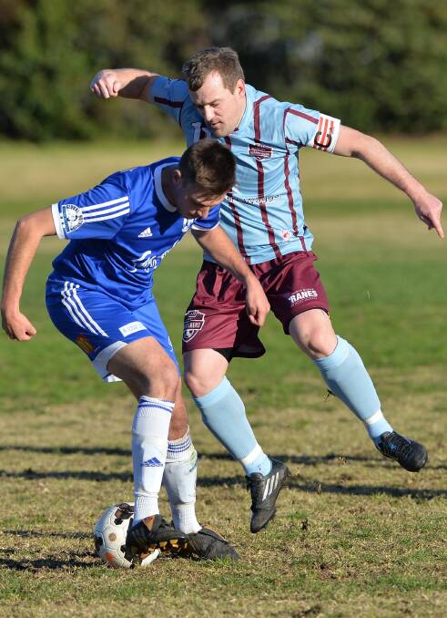 Wanderers captain Justin Curran competes for the ball with Hanwood player Demetrio Torino.