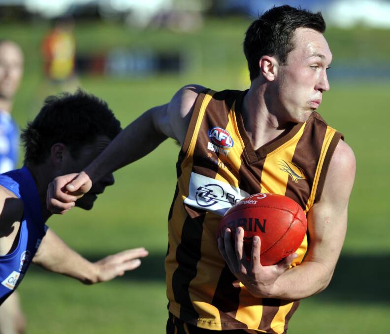 EWK player Jacob Tiernan fights his way out of traffic at Maher Oval.