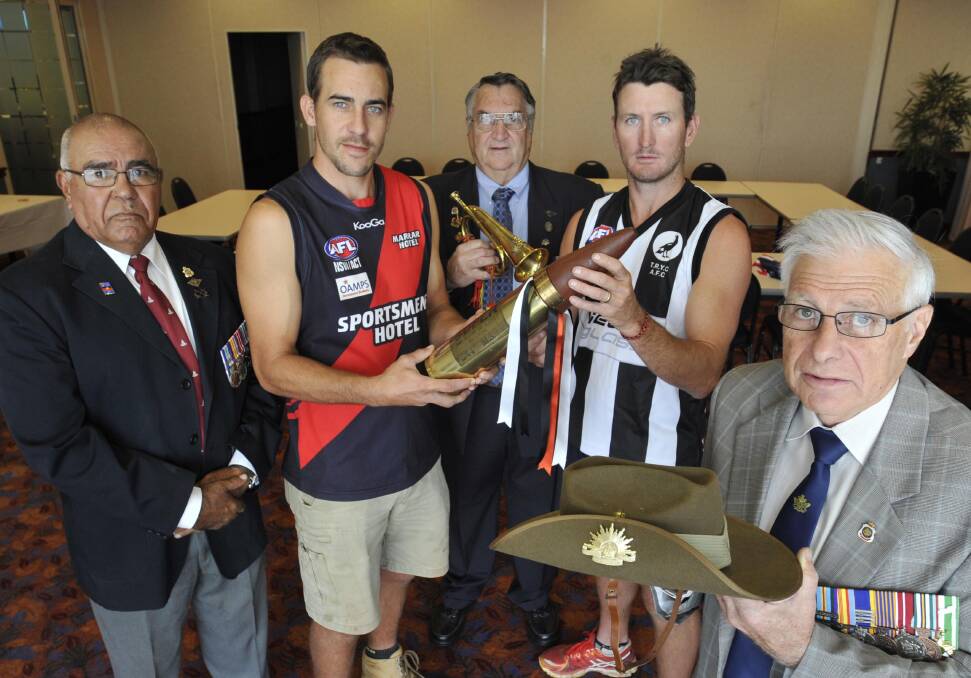 Marrar coach Clint Taylor and TRYC coach Dave Pieper get their hands on the Anzac Challenge shell, alongside veterans Hewitt Whyman, Les White and Des Davie at the Rules Club.