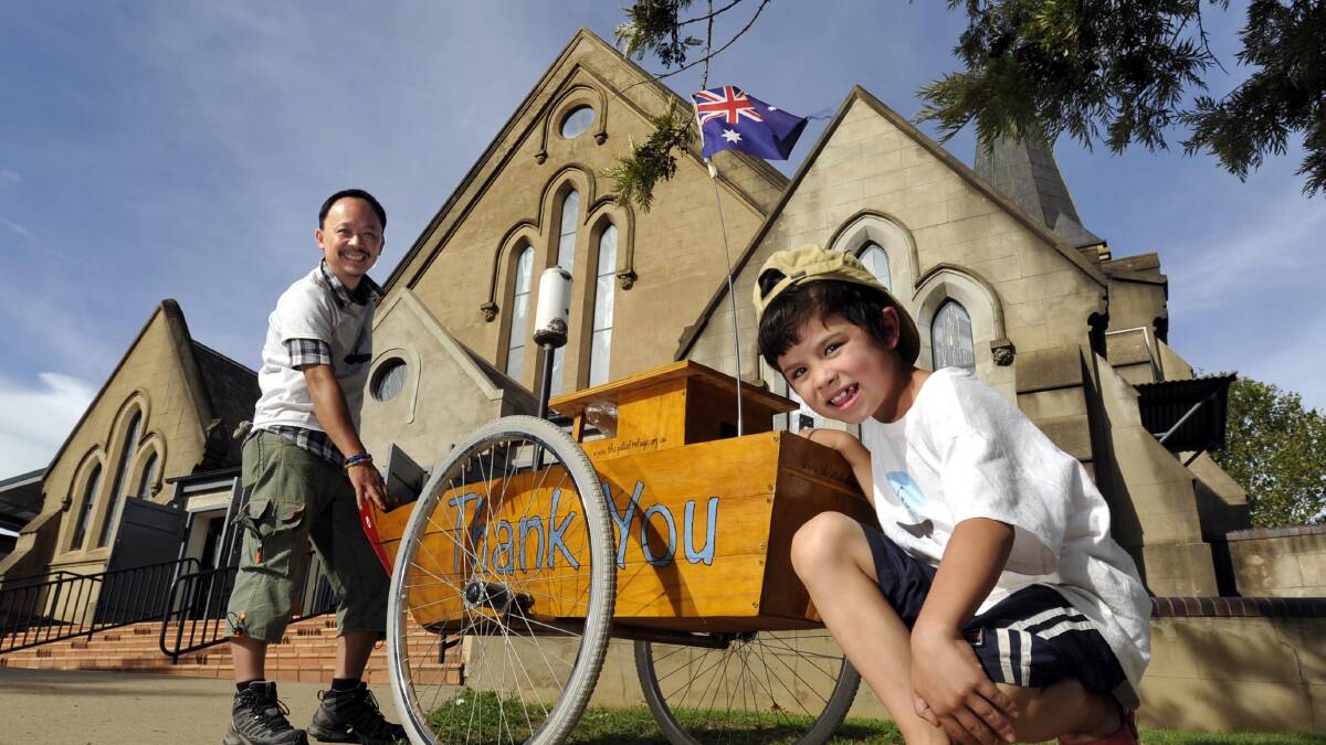 Tri Nguyen is hauling a large model of the boat in which his family fled from Vietnam in 1982 from Melbourne to Canberra. He stopped in Wagga and was officially welcomed at St John's Anglican Church. He is pictured with son Noah. Picture: Les Smith