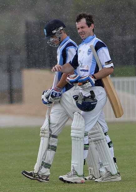 South Wagga's Michael Mattingly and Matt Bee leave the field as a heavy shower halts play during the South Wagga v Wagga City game at Robertson Oval on Saturday. Picture: Michael Frogley