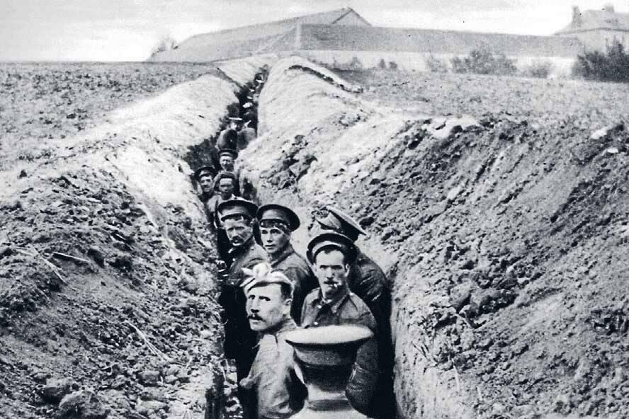 October 1914: British soldiers line up in a narrow trench during World War I.
