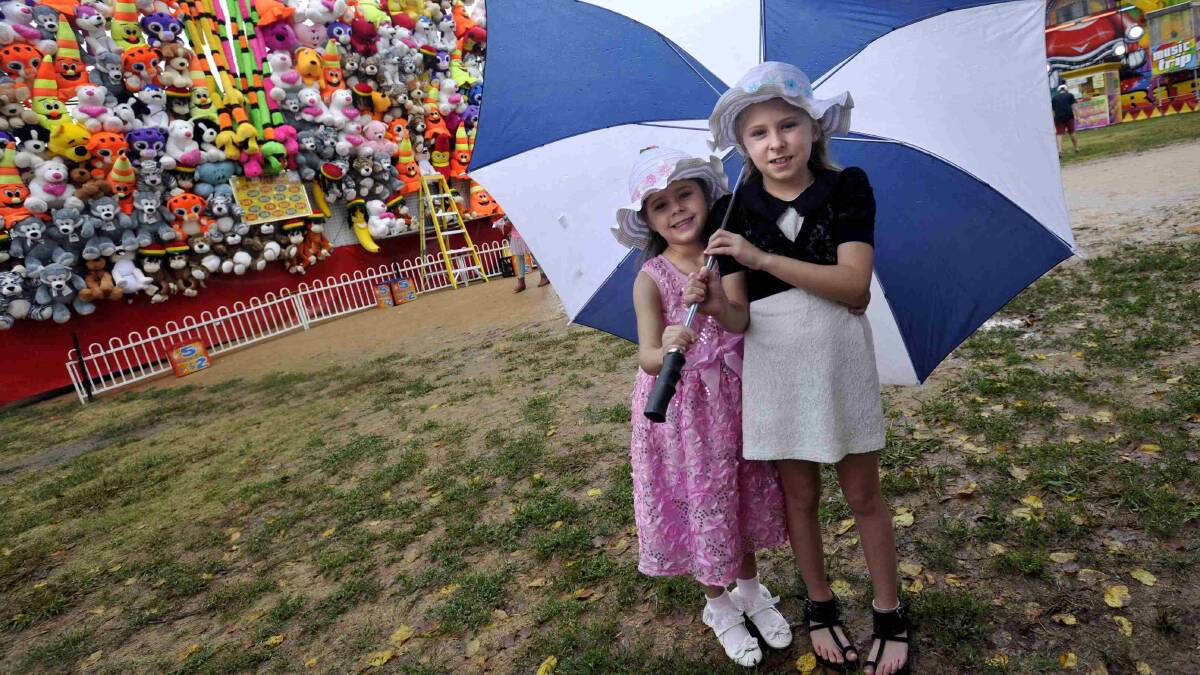 Rhianna, 5, and Alarna Polsen, 8, check out the attractions as rain falls at the Gundagai show. Picture: Les Smith