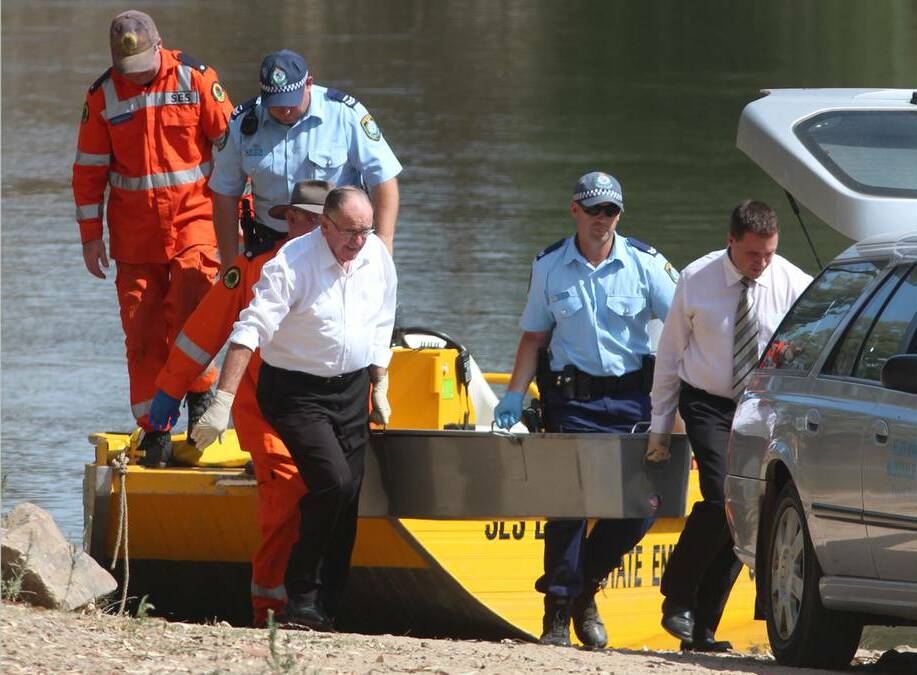 Police, SES volunteers and funeral home staff transfer the body of 19-year-old Chris Sahn from a rescue boat on January 20. Picture: Andrew Pearson