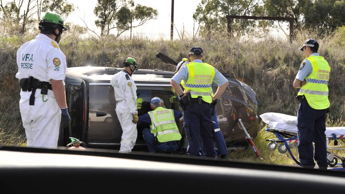 Emergency services personnel free a trapped passenger at an accident near Uranquinty. Picture: Les Smith