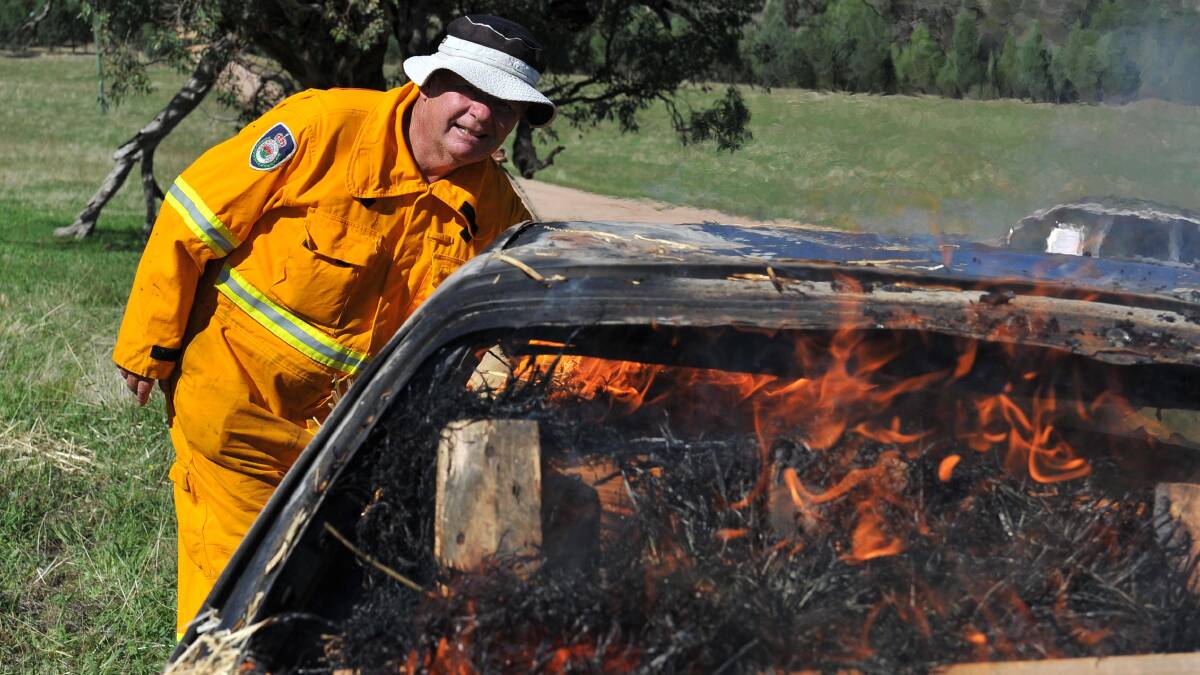 Greg Turnell of Lake Albert RFS sets a car on fire for an RFS training exercise at Gregadoo Hills at the weekend. Picture: Michael Frogley