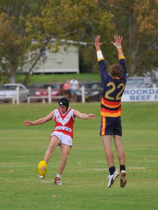 CAK's Jack Egan tries to kick past Crow Mick Cunningham in the Charity Shield game between Collingullie-Ashmont-Kapooka and Billabong Crows at Narrandera. Picture: Kieren L Tilly