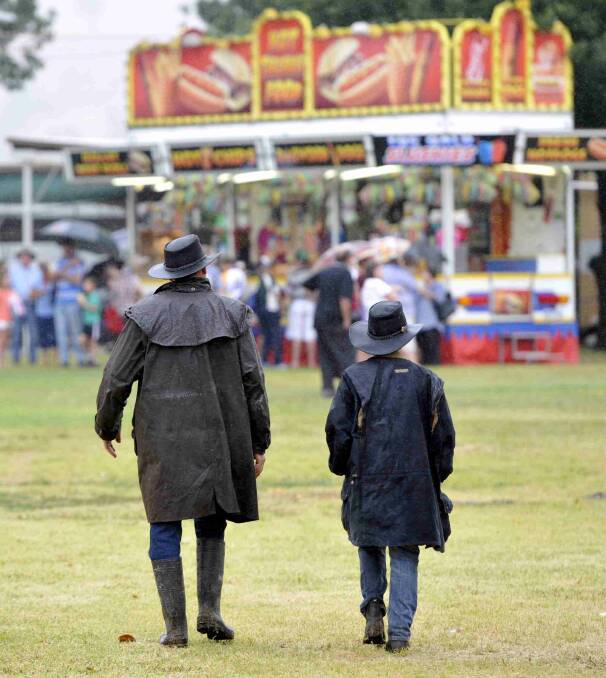 Bungendore's Jack Campbell and son Scott, 12, on the way to sideshow alley between rounds of the sheedog trials at the Gundagai show. Picture: Les Smith