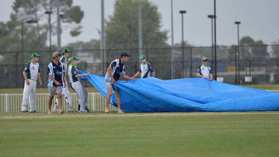 There was a quick dash to get the wicket covered as a heavy shower halts play during the South Wagga v Wagga City game at Robertson Oval on Saturday. Picture: Michael Frogley
