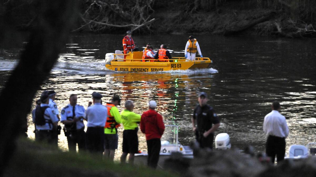Emergency personnel line the bank of the Murrumbidgee River at Wiradjuri Reserve late yesterday afternoon as a body, believed to be that of missing man Brent Little, is recovered from the water on Tuesday afternoon. Picture: Les Smith
