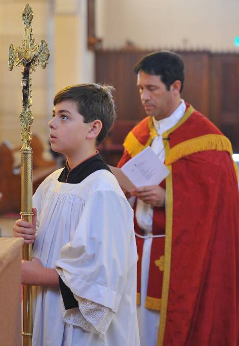 Father Rick Micallef leads the Stations of the Cross Easter celebrations at St Michaels Cathedral in Wagga. His was assisted by cross bearer Gerard Letchford, 12. Picture: Kieren L Tilly