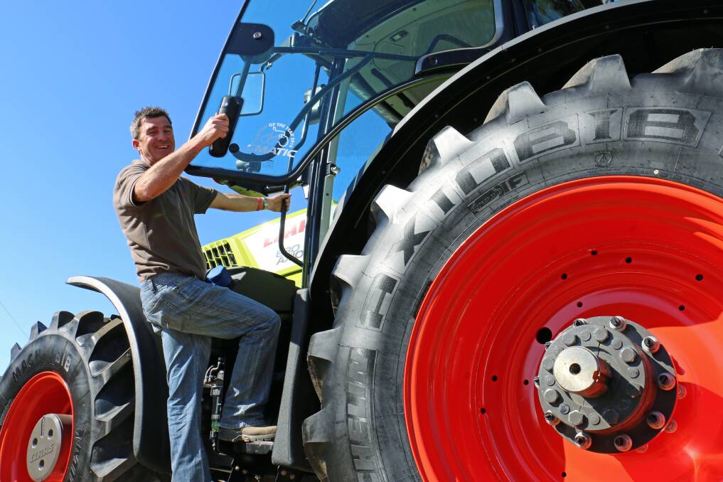 Geoff Anderson,a sales representative at CLAAS Harvest Centre Wagga, inspects the 2014 Tractor of the Year - the CLAAS AXION 800 - which will debut at the Henty Machinery Field Days on Tuesday. Picture: Kim Woods