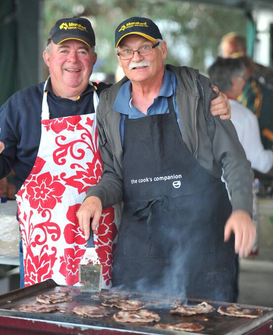 Peter Quinane (left) and John Killalea from the Wagga's Men's Shed at work on the BBQ to feed the hungry crowds. Picture: Kieren L Tilly