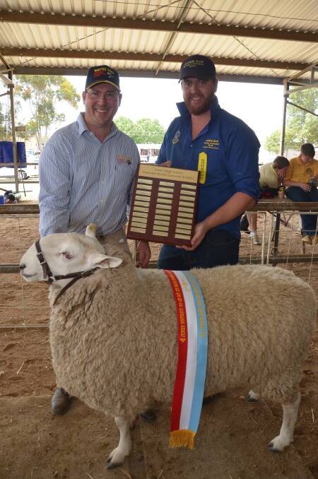 Jeff Sutton from Temora's Wattle Farm sheep stud is presented with the Junee High School supreme border leiscester exhibit trophy by steward and agriculture teacher Paul Anderson. Picture: Declan Rurenga