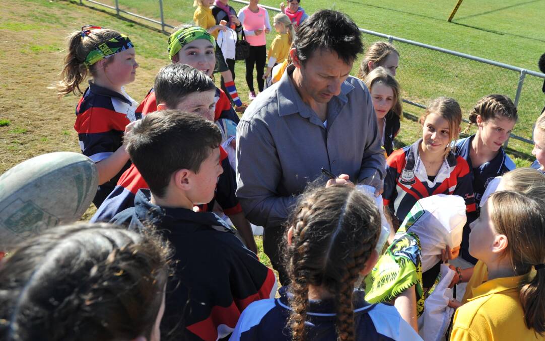 Laurie Daley, surrounded by kids at the Mortimer Shield final at Wagga on Tuesday, will return to Junee for the Riverina Schoolboys Carnival on 
