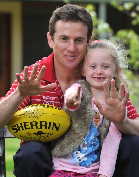 ELEVENTH HEAVEN: Collingullie-Ashmont-Kapooka co-captain Chris Gow needs five-year-old daughter Marley's help to display just how many grand finals he's played in for the Demons. Picture: Michael Frogley