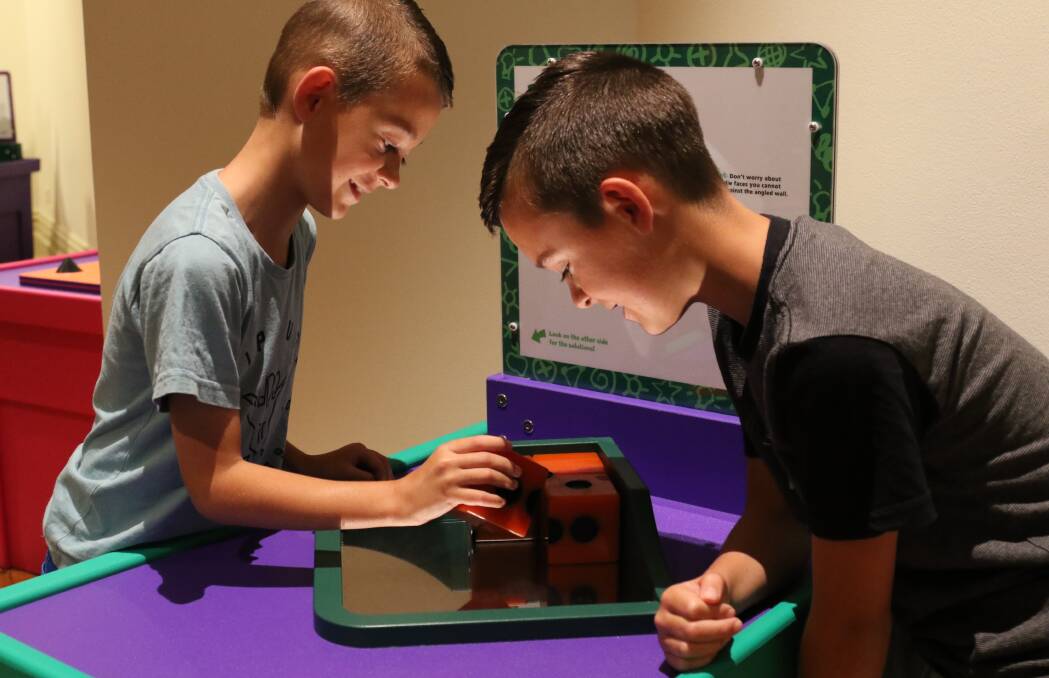 HOLIDAY WORKOUT: Dimitri and Zavier Koutantos, visiting from Sydney, solve a puzzle in Questacon's Fascinating Science exhibition.