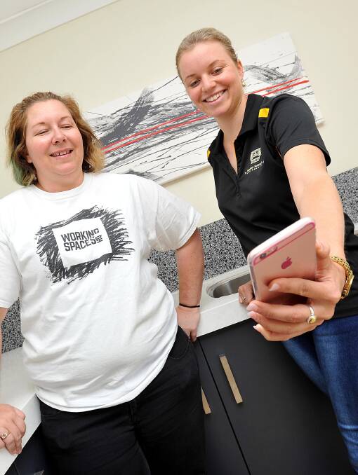 IN IT TO WIN IT: Wagga businesswoman Sally Cannon shows local entrepreneur Simone Eyles a glimpse of her new app ahead of a new business competition.